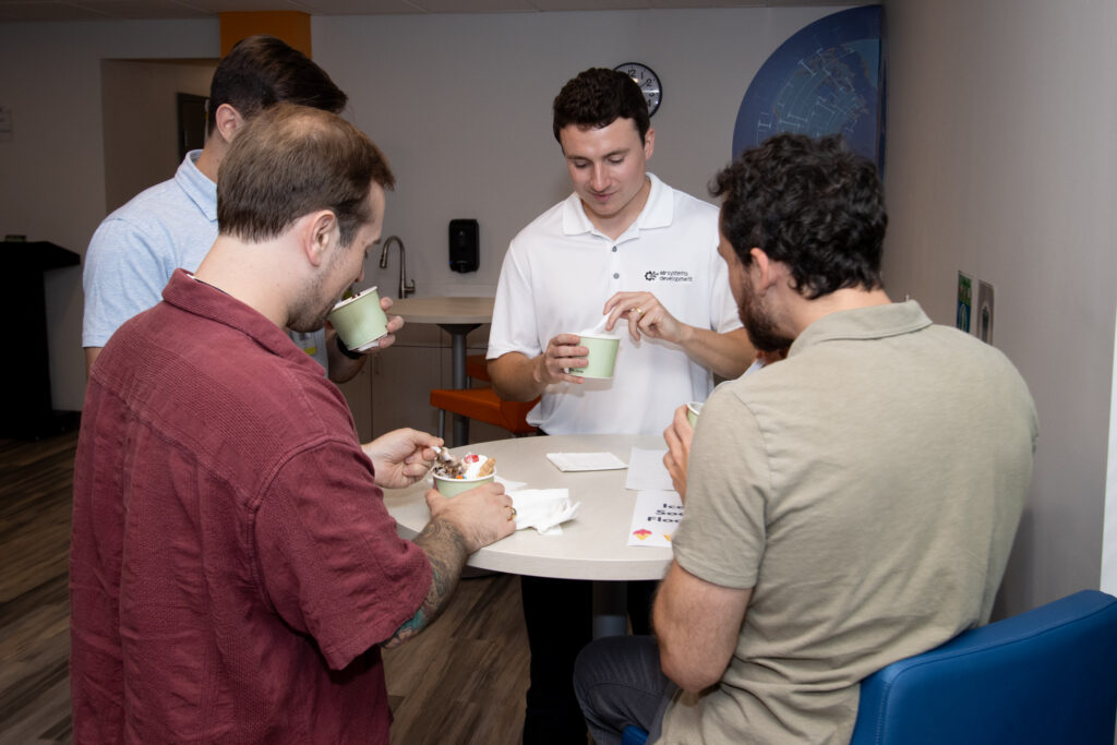 Colleagues enjoy ice cream together at a casual gathering in a modern office space.